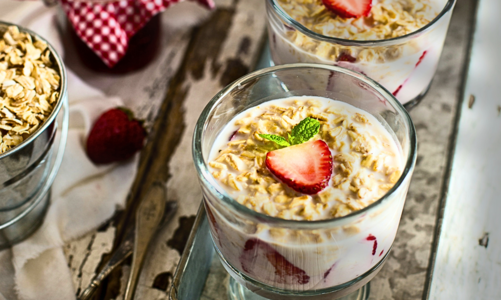 Two glasses with overnight oats with almond milk and strawberries for breakfast