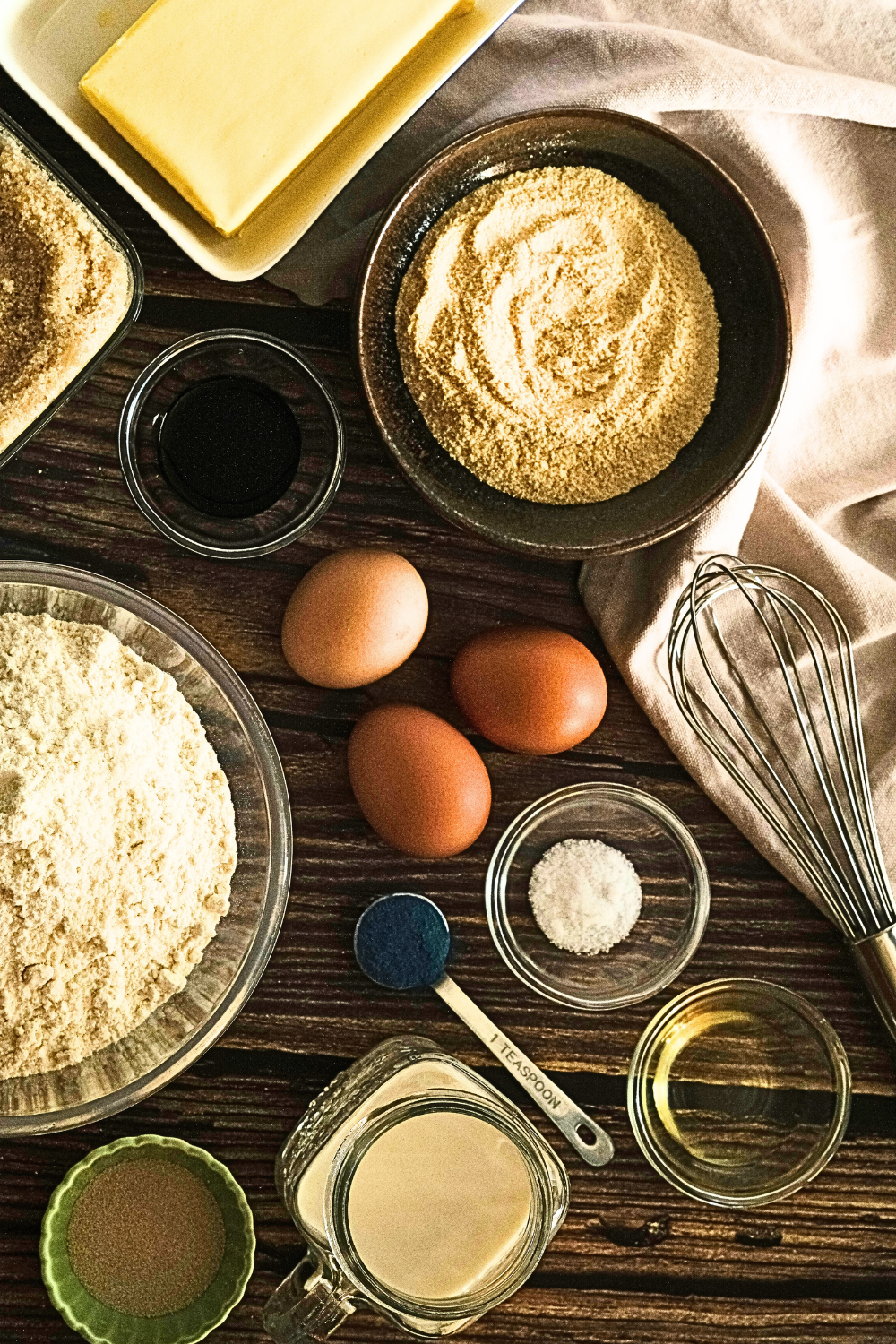 Table with ingredients to prepare protein baked goods: protein powder, eggs, butter, flour. milk powder