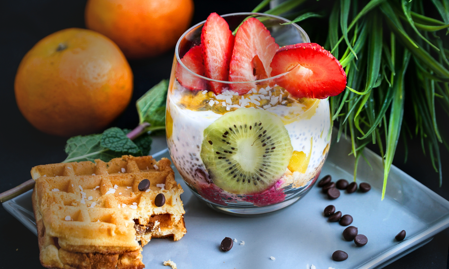 A breakfast spread with eggs, yogurt, oats, and berries on a wooden table