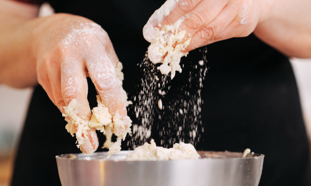 Hands mixing protein-enriched batter in a bowl