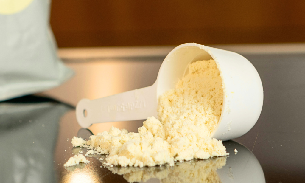 Scoop of whey protein powder on a table